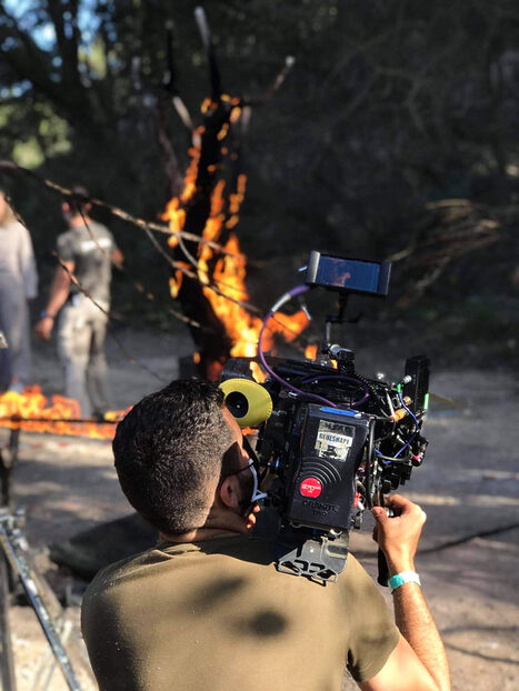 Director of Photography filming someone burning